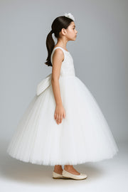 Young girl wearing a white dress with a gray background